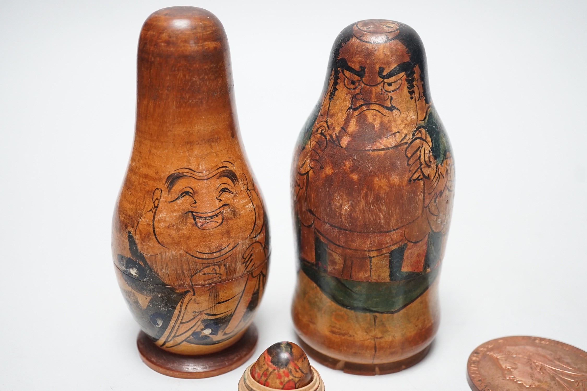 Two Japanese stacking dolls and various medallions